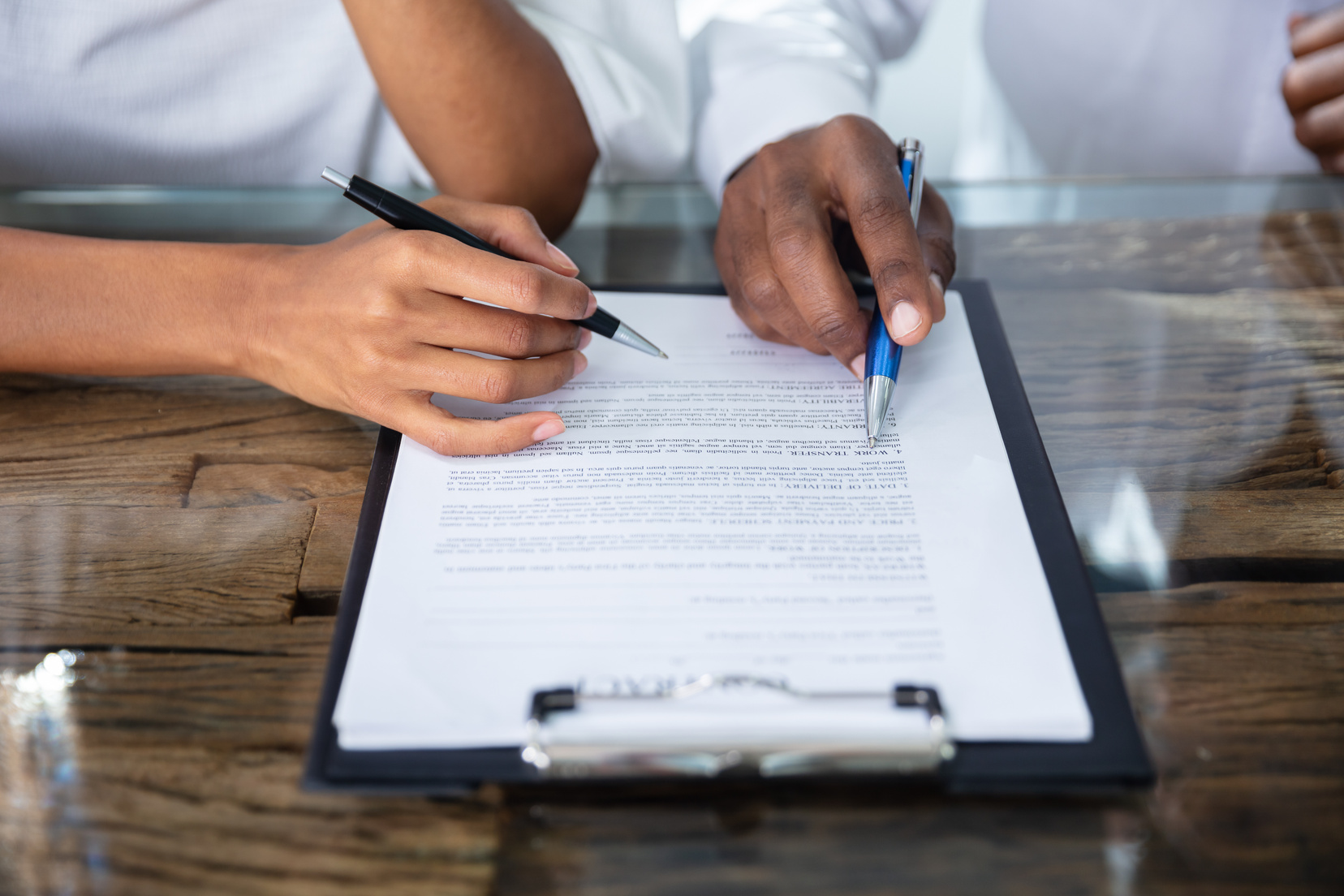 Two Person's Hand Reviewing Contract Form